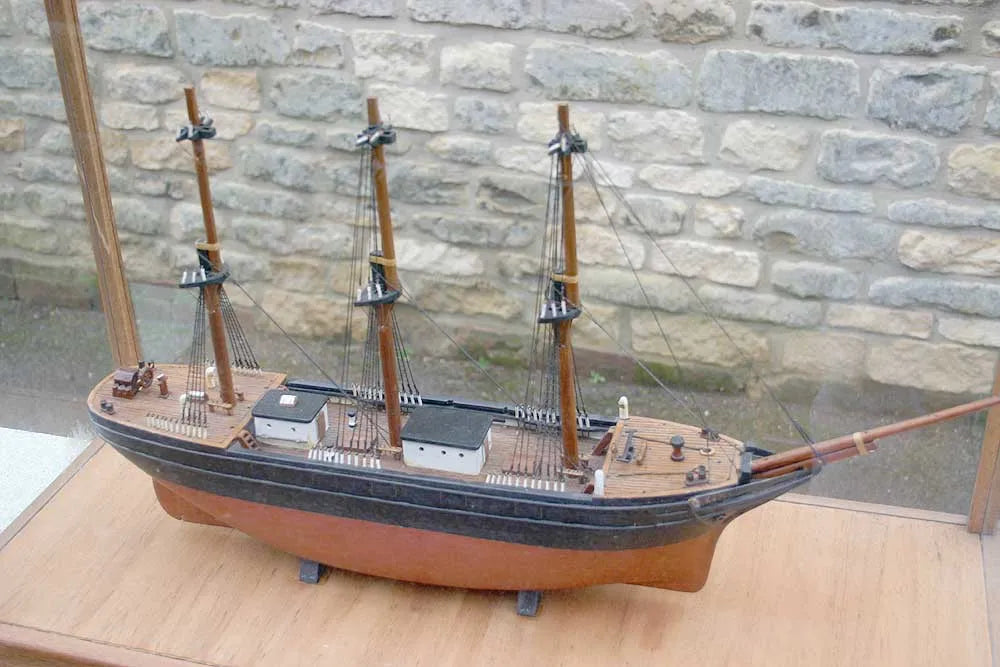 Wooden sailing ship in glass case